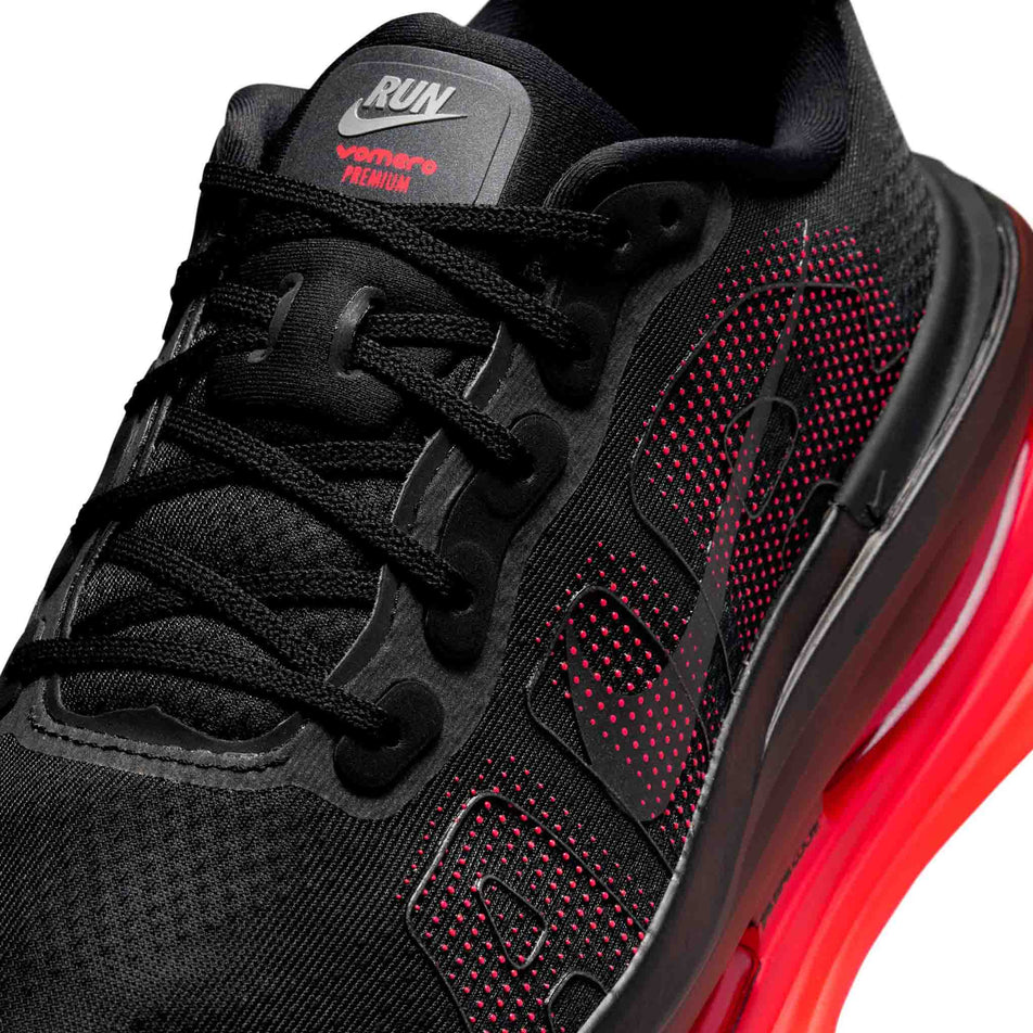 Close-up view of the upper of the left shoe from a pair of Nike Men's Vomero Premium Road Running Shoes in the Black/Black-Bright Crimson colourway.