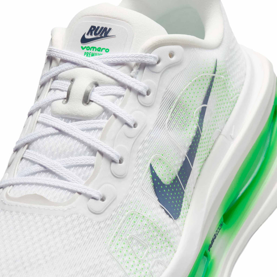 Close-up view of the upper of the left shoe from a pair of Nike Men's Vomero Premium Road Running Shoes in the White/Midnight Navy-Green Spark colourway.