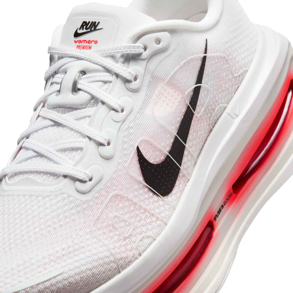Close-up view of the upper of the left shoe from a pair of Nike Men's Vomero Premium Road Running Shoes in the White/Black-Bright Crimson-Photon Dust colourway.