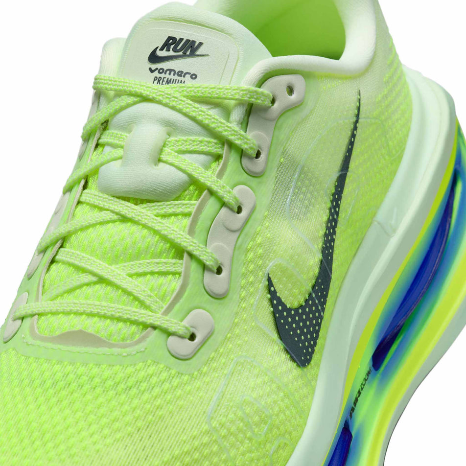 Close-up view of the upper of the left shoe from a pair of Nike Men's Vomero Premium Road Running Shoes in the Volt Tint/Black Spruce-Sapphire-Volt colourway.