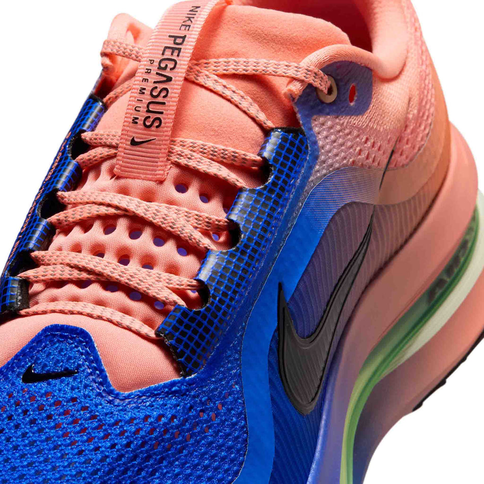 Close-up view of the upper of the left shoe from a pair of Nike Men's Pegasus Premium Road Running Shoes in the Racer Blue/Black-Atomic Pink-Volt Tint colourway.