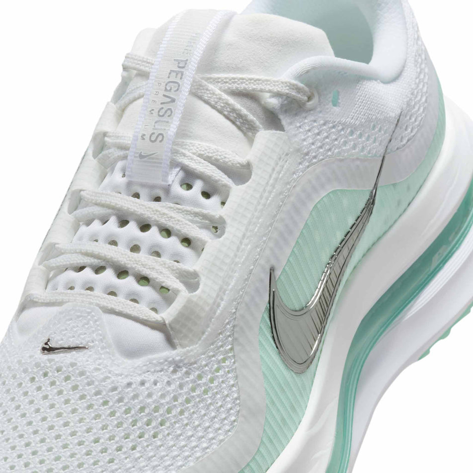 Close up of the upper of the left shoe from a pair of Nike Women's Pegasus Premium Road Running Shoes in the White/Metallic Silver-Mint Foam-Cannon colourway. (8684688933026)