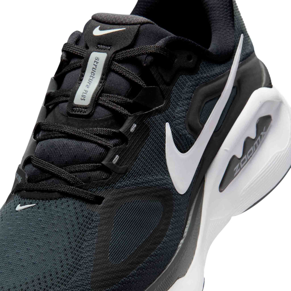 Close-up view of the upper of the left shoe from a pair of Nike Men's Structure Plus Road Running Shoes in the Black/White-Anthracite colourway.