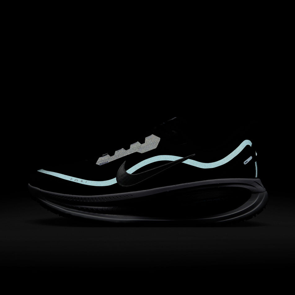 The reflective details on the lateral side of the left shoe from a pair of Nike Men's Vomero 18 GORE-TEX Road Running Shoes in the Black/Metallic Silver-Anthracite-White colourway. (8754898501794)
