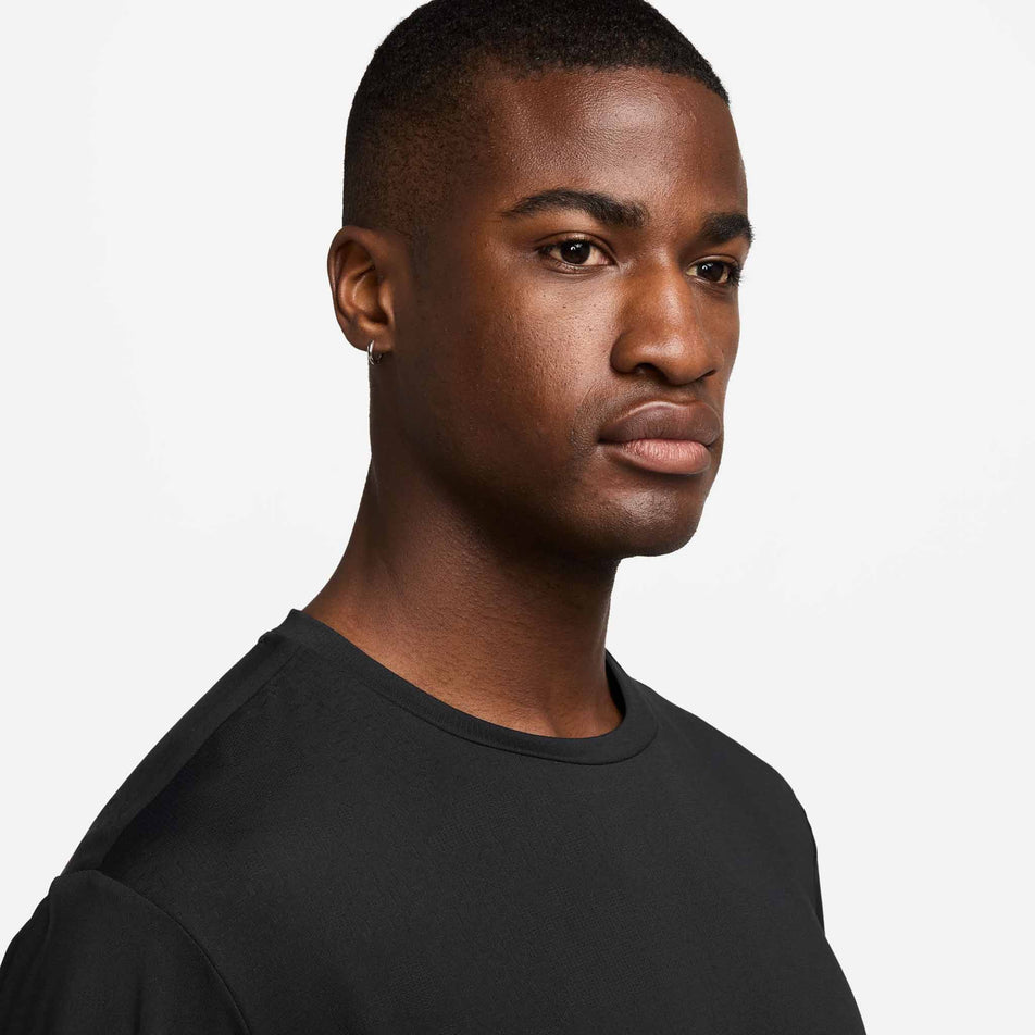 Angled view of a model wearing the Nike Men's Dri-FIT ADV Run Pinnacle Short-Sleeve Running Top in the Black/Blackref colourway. (8710811615394)