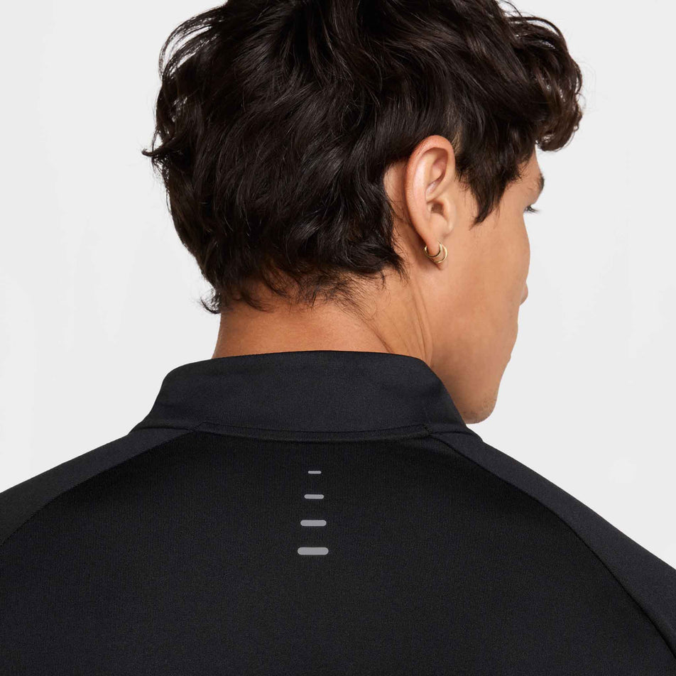 Back view of a model wearing the Nike Men's Stride Dri-FIT 1/4-Zip Running Top in the Black/Reflective Silver colourway. (8778198876322)