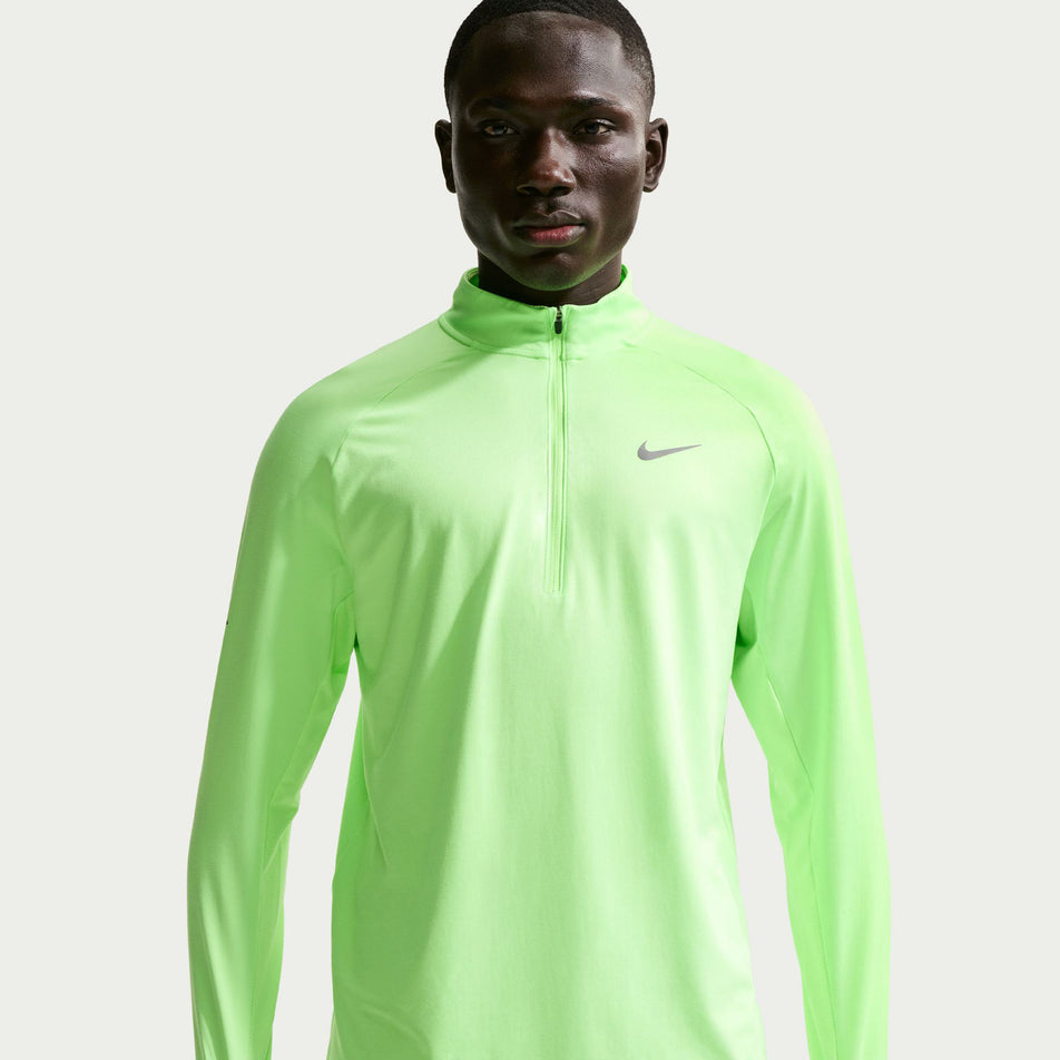 Front view of a model wearing the Nike Men's Stride Dri-FIT 1/4-Zip Running Top in the Lime Blast/Reflective Silver colourway.