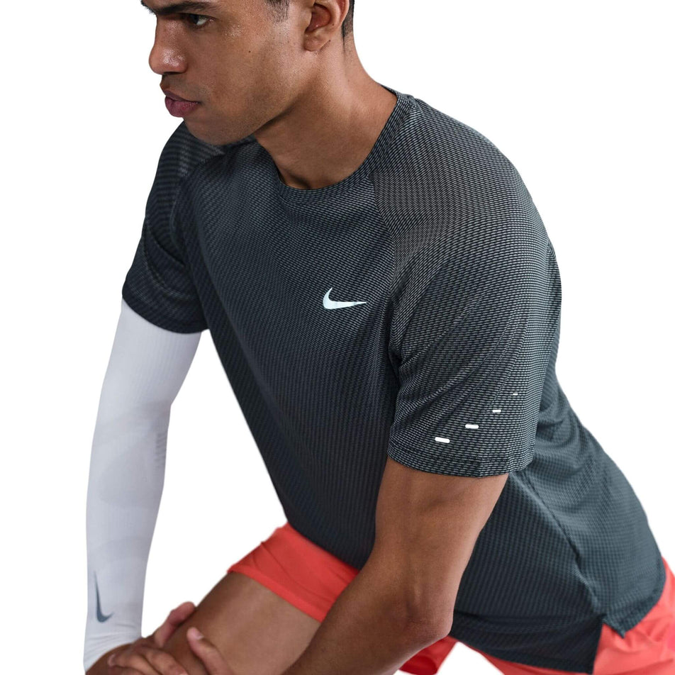 Angled view of a model wearing the Nike Men's Dri-FIT Stride Jacquard Short-Sleeve Running Top in the Black/Reflective Silver colourway. (8716705202338)