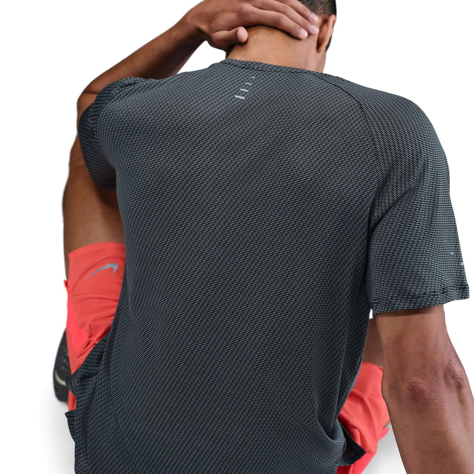 Back view of a model wearing the Nike Men's Dri-FIT Stride Jacquard Short-Sleeve Running Top in the Black/Reflective Silver colourway. (8716705202338)