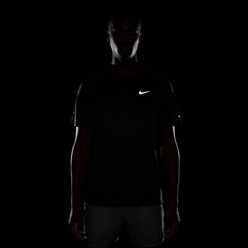 The reflective Nike Swoosh on the front of the Nike Men's Dri-FIT Stride Jacquard Short-Sleeve Running Top in the Black/Reflective Silver colourway. (8716705202338)