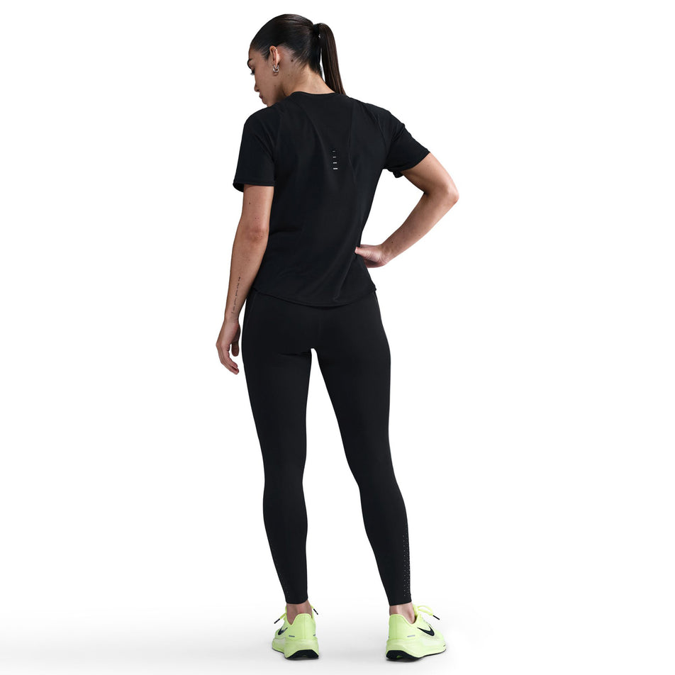 Back view of a model wearing the Nike Women's Swift High-Waisted 7/8 Running Leggings in the Black/Dark Smoke Grey colourway. (8756531626146)