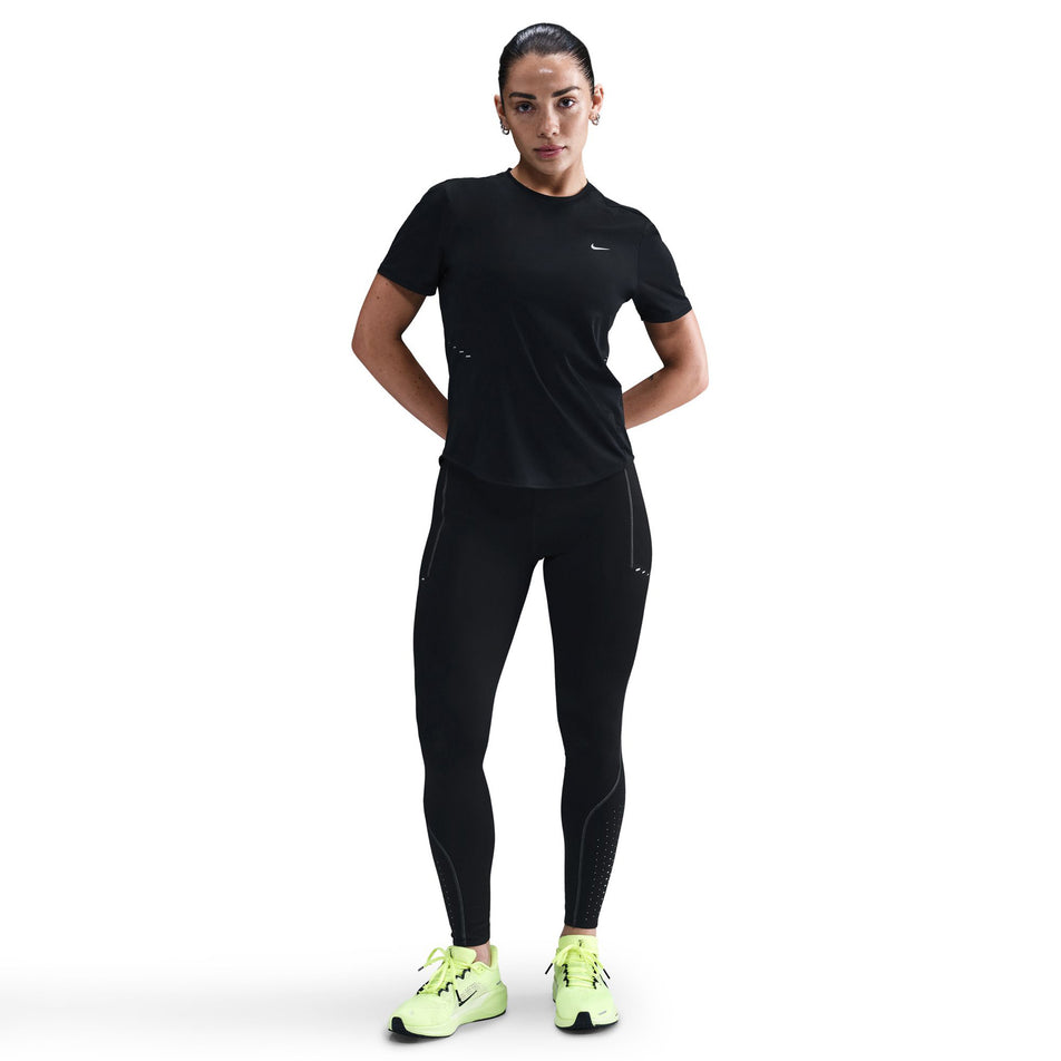Front view of a model wearing the Nike Women's Swift High-Waisted 7/8 Running Leggings in the Black/Dark Smoke Grey colourway. (8756531626146)