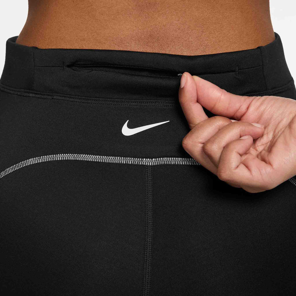 The zippered pocket on the back of the Nike Women's Swift High-Waisted 7/8 Running Leggings in the Black/Dark Smoke Grey colourway. (8756531626146)