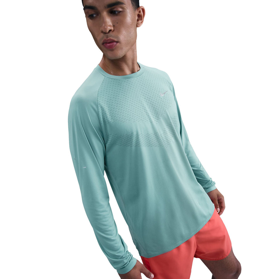 Front view of a model wearing the Nike Men's Stride Dri-FIT ADV Long-Sleeve Running Top in the Cannon/Reflective Silver colourway. (8778197172386)