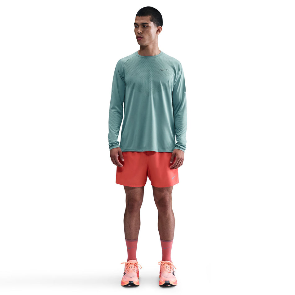 Front view of a model wearing the Nike Men's Stride Dri-FIT ADV Long-Sleeve Running Top in the Cannon/Reflective Silver colourway. (8778197172386)