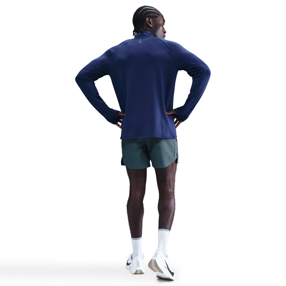 Back view of a model wearing the Nike Men's Stride Therma-FIT Repel Winterized 1/2-Zip Running Top in the Blue Void/Reflective Silver colourway. (8778201989282)