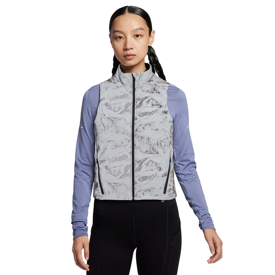 Front view of a model wearing the Nike Women's Therma-FIT ADV Reflective Running Vest in the Vast Grey/Black colourway. (8756535394466)