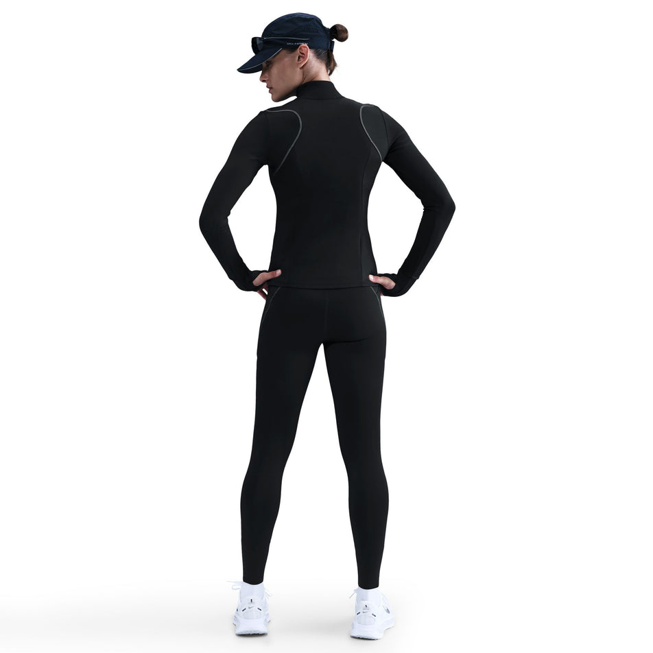 Back view of a model wearing the Nike Women's Swift Therma-FIT ADV 1/4-Zip Running Top in the Black/Reflective Silver colourway. (8756532904098)