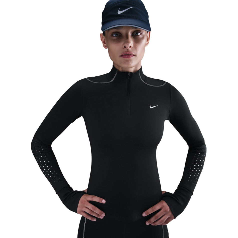 Front view of a model wearing the Nike Women's Swift Therma-FIT ADV 1/4-Zip Running Top in the Black/Reflective Silver colourway. (8756532904098)