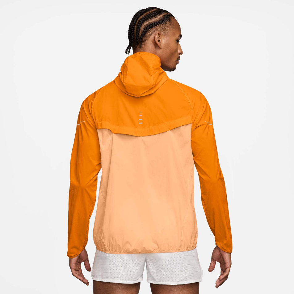 Back view of a model wearing the Nike Men's Stride Repel UV Running Jacket in the Bright Ceramic/Reflective Silver colourway. (8778203693218)