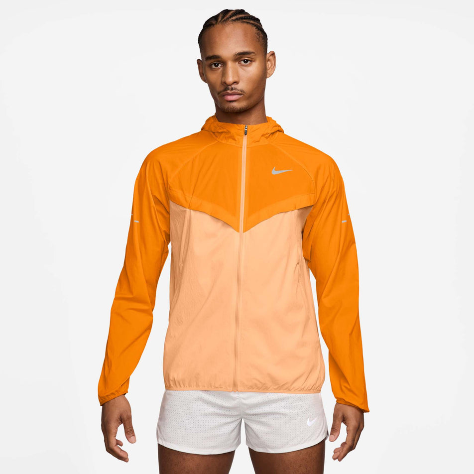 Front view of a model wearing the Nike Men's Stride Repel UV Running Jacket in the Bright Ceramic/Reflective Silver colourway. (8778203693218)
