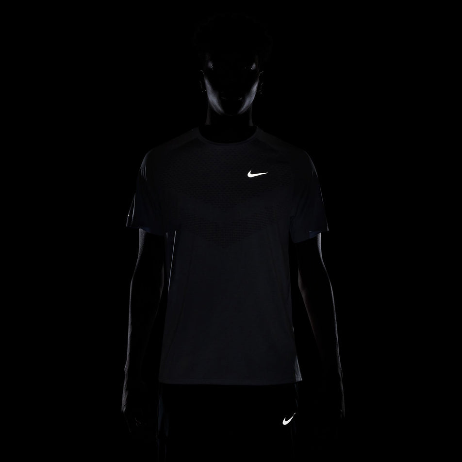 The reflective Nike Swoosh on the front of the Nike Men's Stride Dri-FIT ADV Short-Sleeve Running Top in the Ghost/Heather/Reflective Silver colourway.(8710942458018)