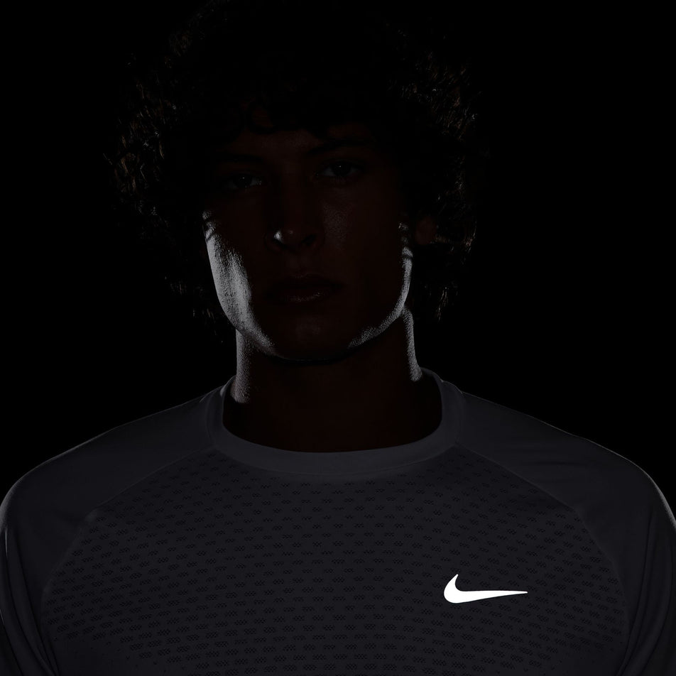 The reflective Swoosh on the front of the Nike Men's Stride Dri-FIT ADV Short-Sleeve Running Top in the White/Reflective Silver colourway. (8620699844770)