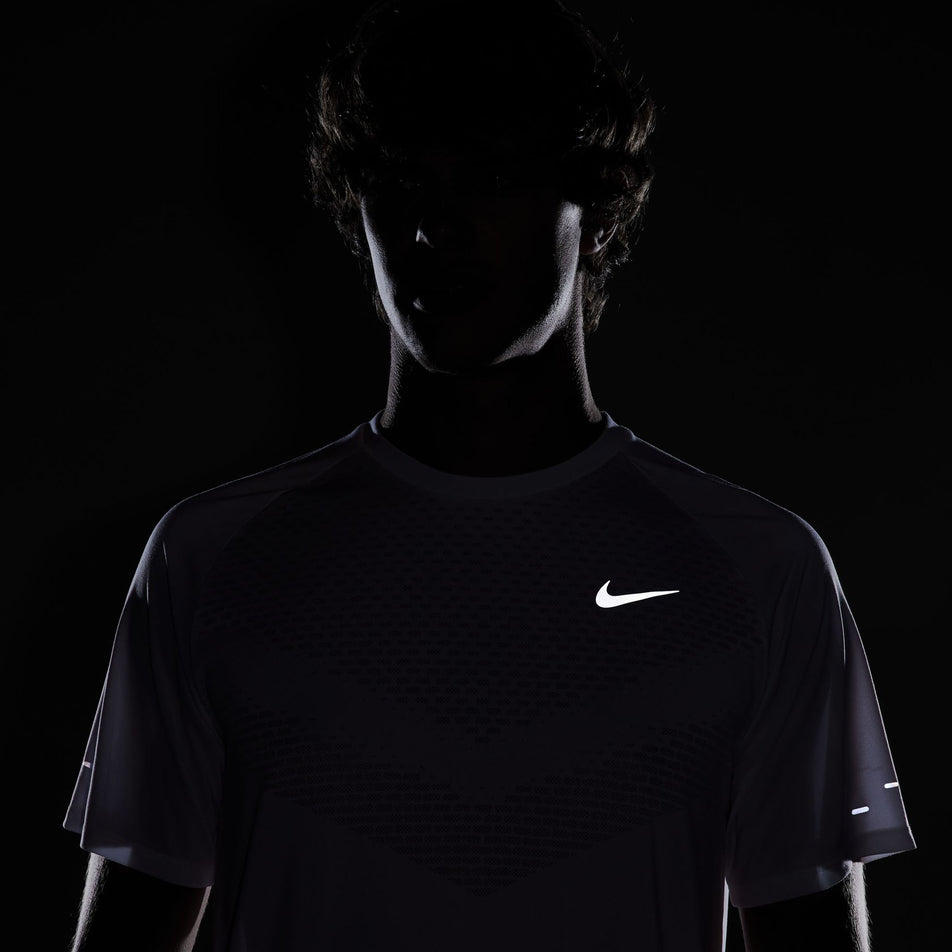 The reflective Swoosh on the front of the Nike Men's Stride Dri-FIT ADV Short-Sleeve Running Top in the White/Reflective Silver colourway. (8620699844770)