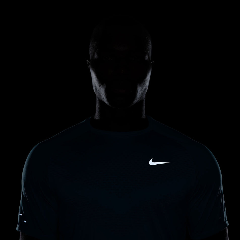 The reflective Nike SWOOSH on the front of the Nike Men's Stride Dri-FIT ADV Short-Sleeve Running Top in the Dusty Cactus/Reflective Silver colourway. (8562852823202)