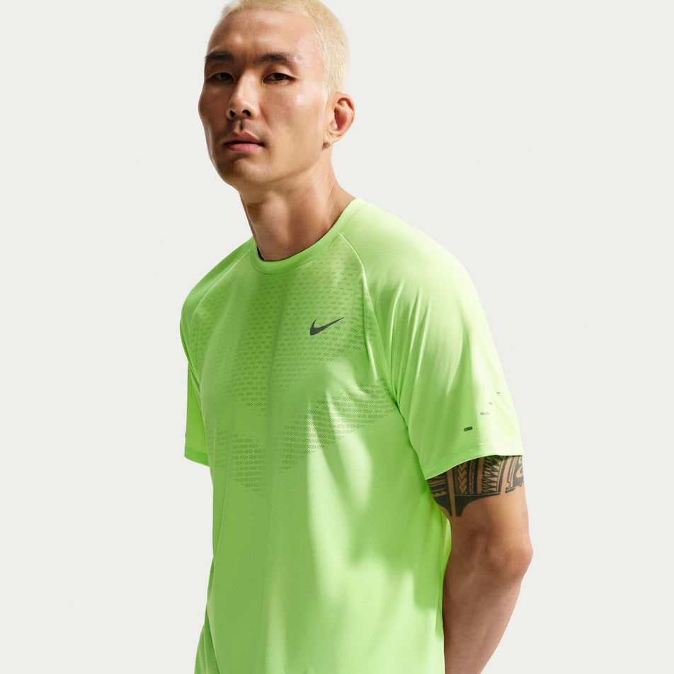 Front view of a model wearing the Nike Men's Stride Dri-FIT ADV Short-Sleeve Running Top in the Lime Blast/Reflective Silver colourway.
