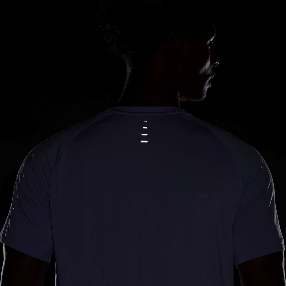 Back view of the reflectivity on the Nike Men's Stride Dri-FIT ADV Short-Sleeve Running Top in the Hydrangeas/Reflective Silv colourway. Top is being worn by a model. (8620701089954)