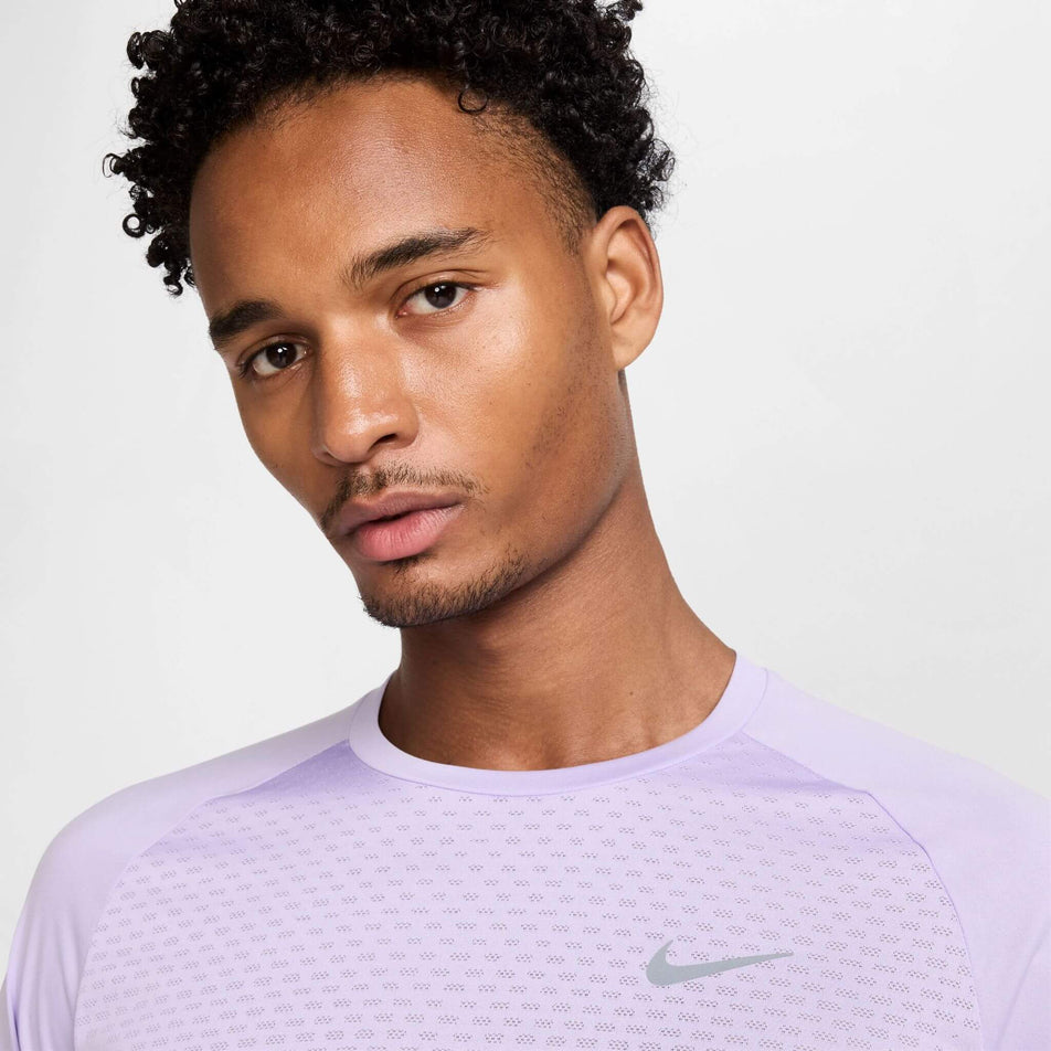 Close-up front view of the chest area of the Nike Men's Stride Dri-FIT ADV Short-Sleeve Running Top in the Hydrangeas/Reflective Silv colourway. Top is being worn by a model. (8620701089954)