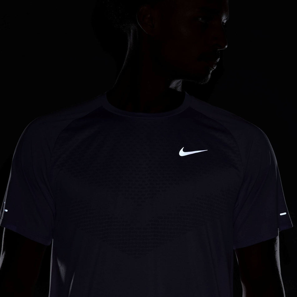 Front view of the reflectivity on the Nike Men's Stride Dri-FIT ADV Short-Sleeve Running Top in the Hydrangeas/Reflective Silv colourway. Top is being worn by a model. (8620701089954)
