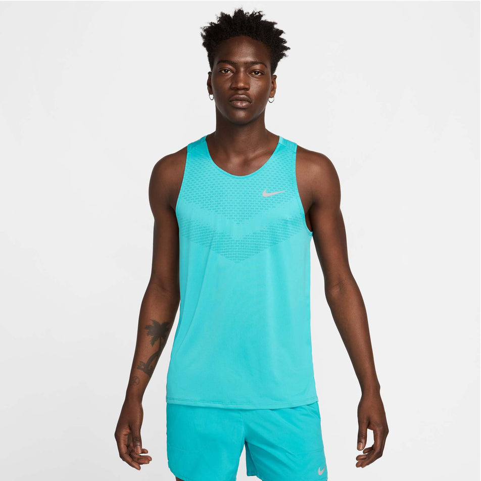 Front view of a model wearing a Nike Men's Stride Dri-FIT ADV Running Tank Top in the Dusty Cactus/Reflective Silver colourway. (8563458703522)