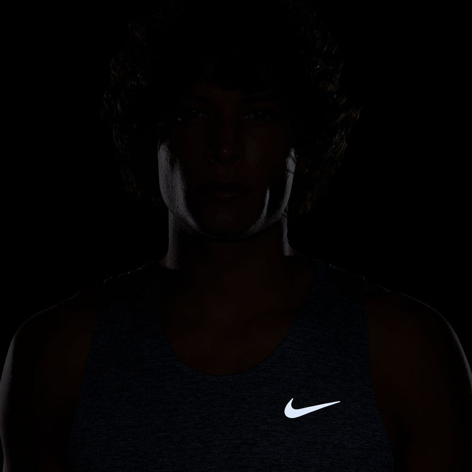 The reflective Swoosh on the front of the Nike Men's Stride Dri-FIT ADV Running Tank Top in the Thunder Blue/Heather/Reflective Silver colourway. (8620703940770)