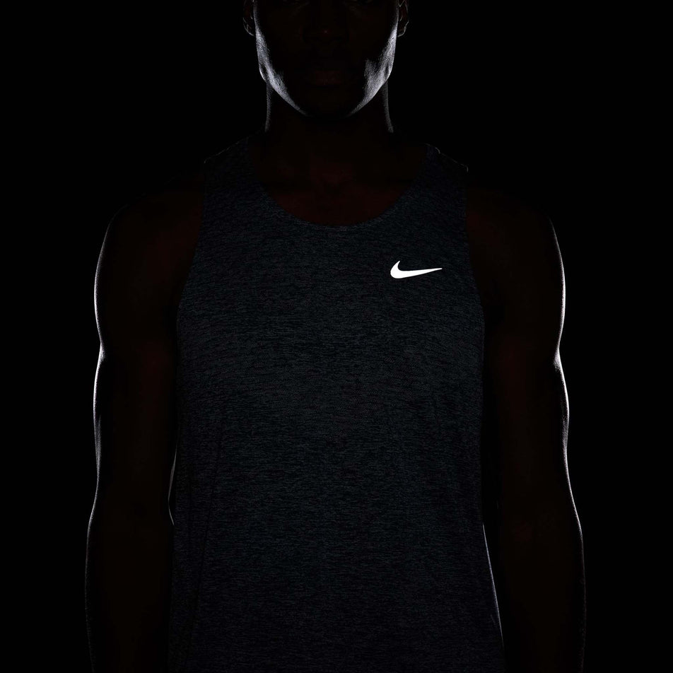 The reflective Swoosh on the front of the Nike Men's Stride Dri-FIT ADV Running Tank Top in the Thunder Blue/Heather/Reflective Silver colourway. (8620703940770)
