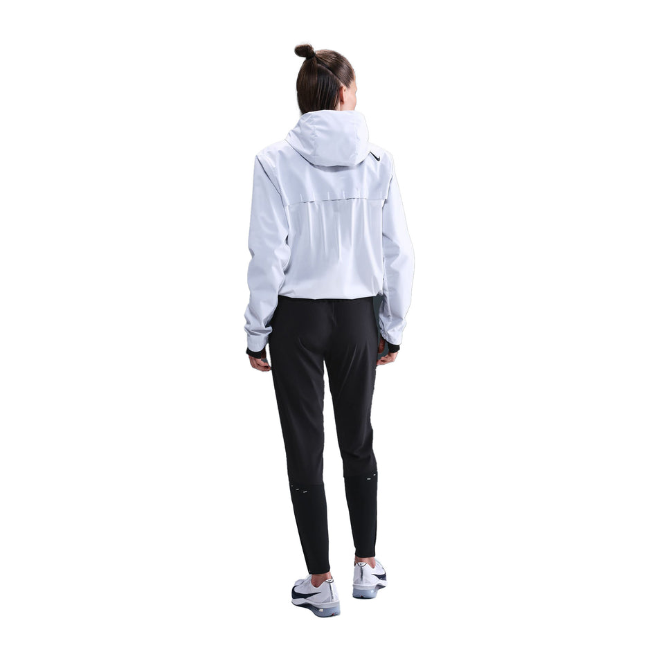 Back view of a model wearing the Nike Women's Dri-FIT Mid-Rise Running Pants in the Black/Reflective Silver colourway. (8732466151586)