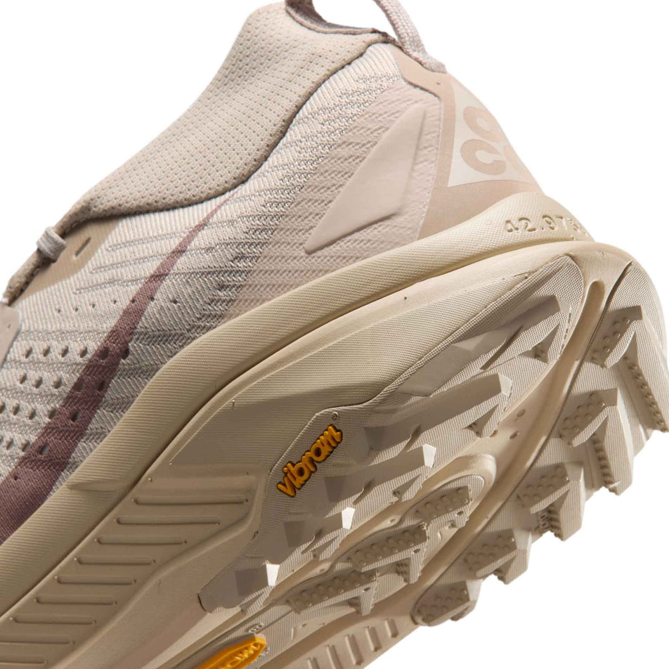 Close-up view of the rearfoot section of the left shoe from a pair of Nike Men's ACG Zegama Trail Running Shoes in the Cream II/Diffused Taupe-Light Orewood Brown colourway.
