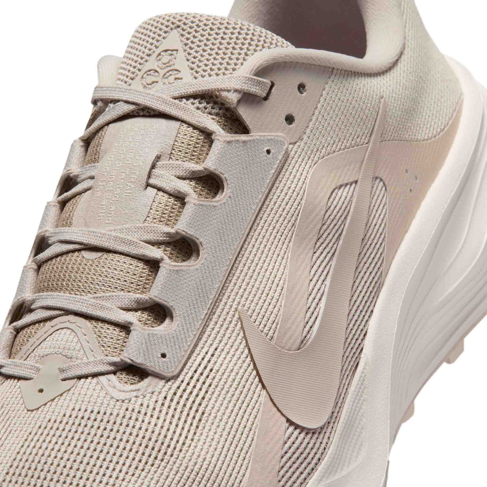 Close-up view of the upper of the left shoe from a pair of Nike Men's ACG Pegasus Trail Running Shoes in the Cream II/Cream II-Light Orewood Brown colourway.