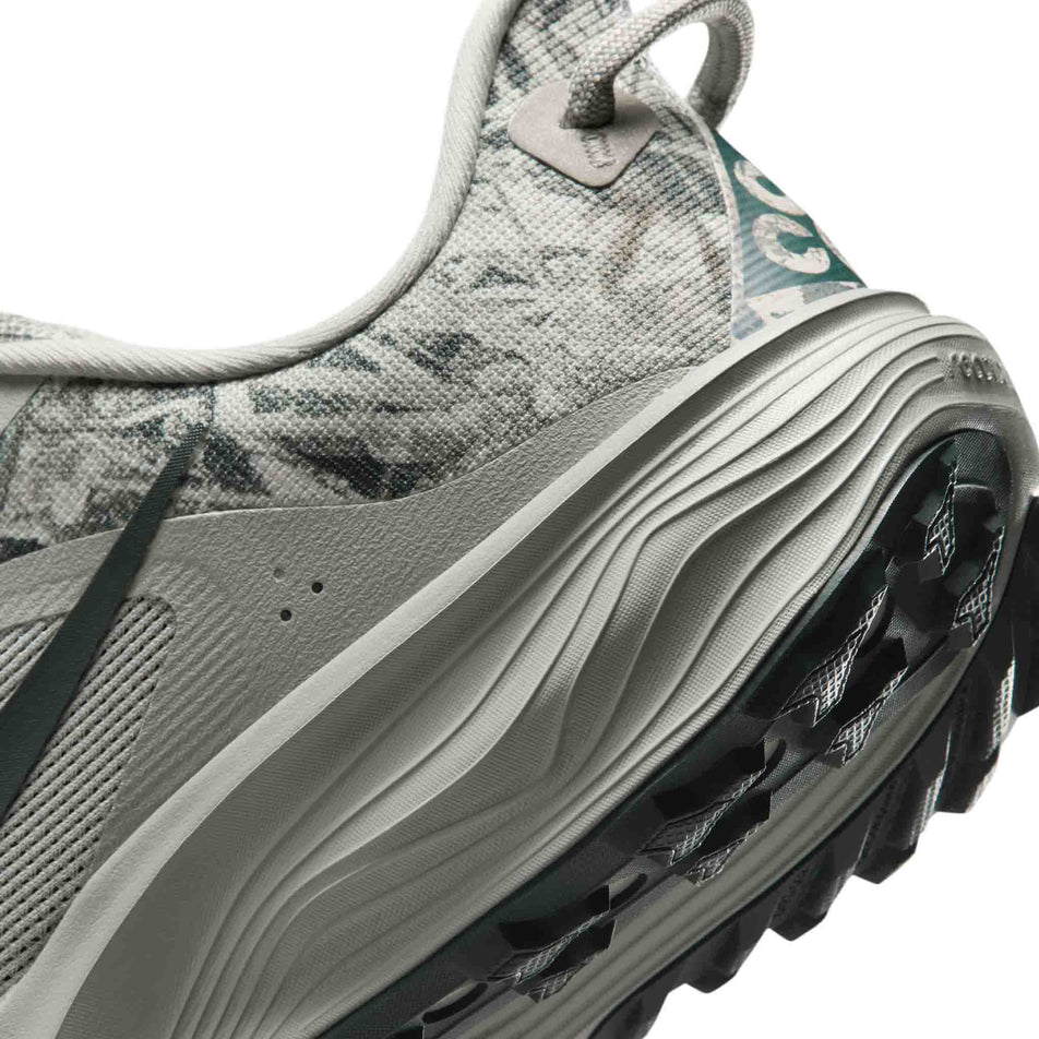Close-up view of the rearfoot section of the left shoe from a pair of Nike Men's ACG Pegasus Trail Running Shoes in the Spruce Fog/Black Spruce-Sea Glass colourway.
