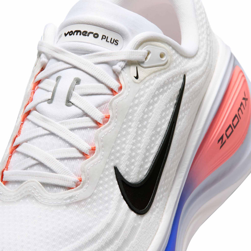 Close-up view of the upper of the left shoe from a pair of Nike Men's Vomero Plus Road Running Shoes in the White/Black-Atomic Pink-Racer Blue colourway.