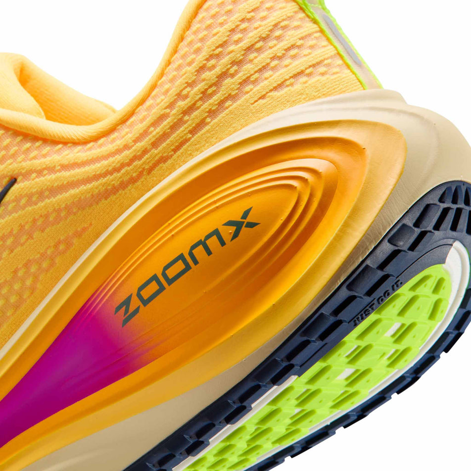 Close-up view of the rearfoot section of the left shoe from a pair of Nike Men's Vomero Plus Road Running Shoes in the Citron Pulse/Blue Void-Alabaster colourway.