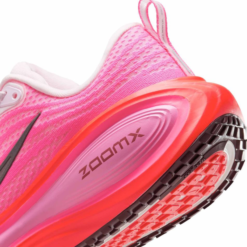 Close-up view of the lateral edge of the midsole of the left shoe from a pair of Nike Women's Vomero Plus Road Running Shoes in the Hyper Pink/Burgundy Crush colourway. (8736251773090)