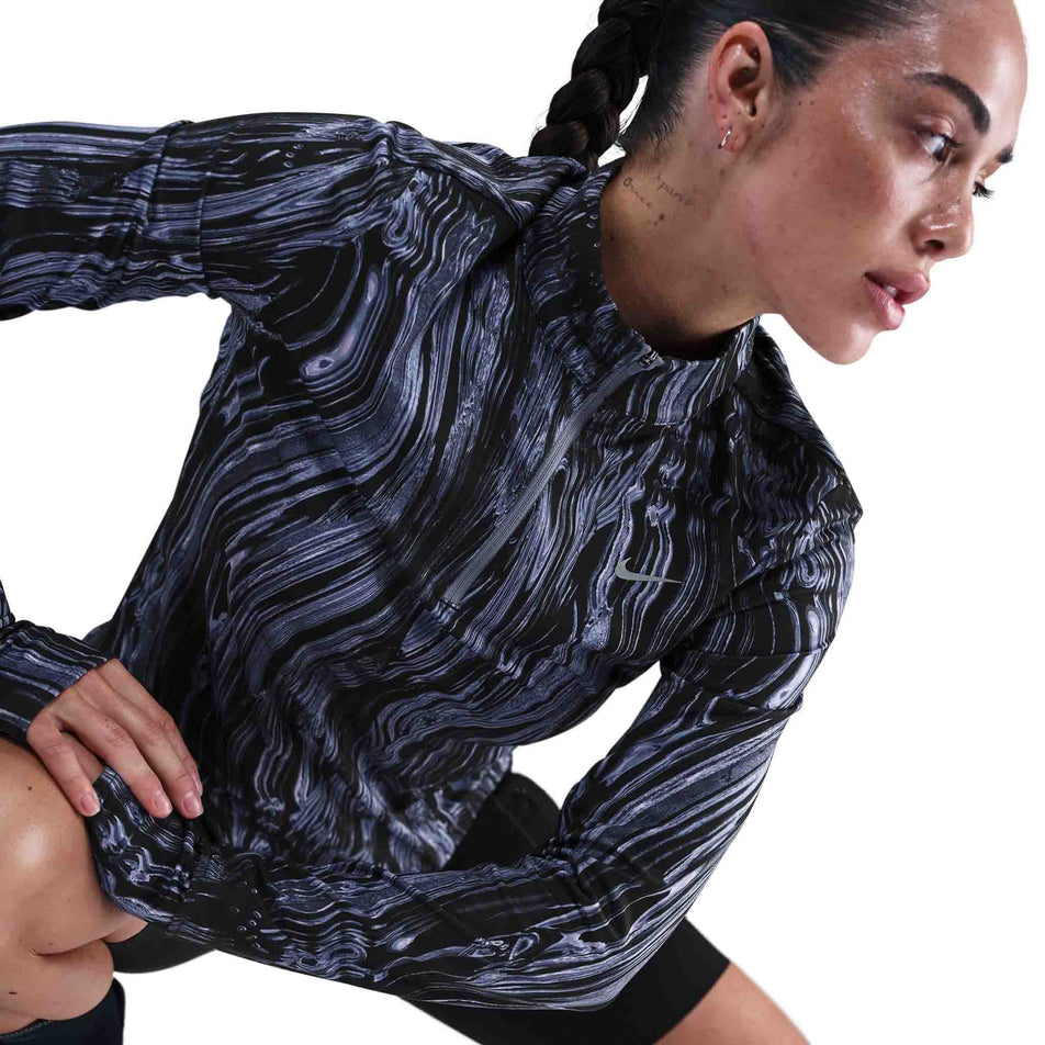 Angled view of a model wearing the Nike Women's Swift Dri-FIT UV 1/2-Zip Printed Running Top in the World Indigo/Reflective Silver colourway. (8782446231714)