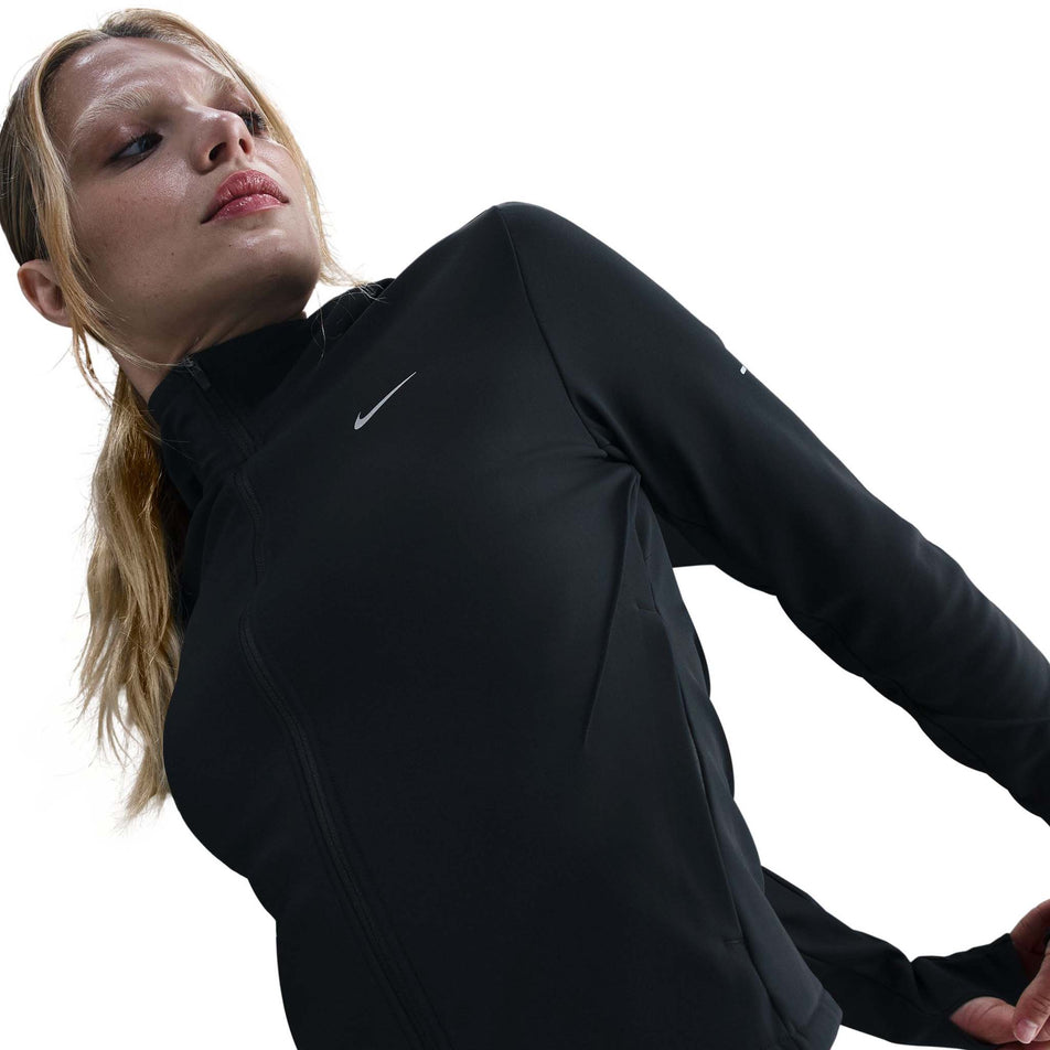 Front view of a model wearing the Nike Women's Swift Therma-FIT Running Jacket in the Black/Reflective Silver colourway.