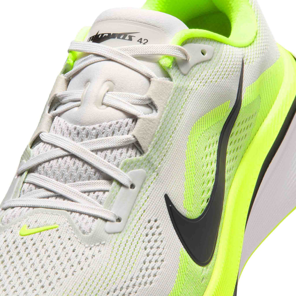 Close-up view of the upper of the left shoe from a pair of Nike Men's Pegasus 42 Road Running Shoes in the Photon Dust/Black-Volt-White colourway.
