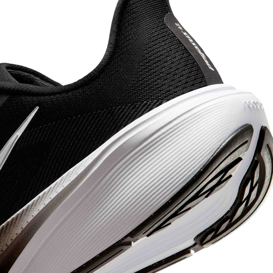Close-up view of the rearfoot section of the left shoe from a pair of Nike Women's Pegasus 42 Road Running Shoes in the Black/White-Iron Grey colourway.