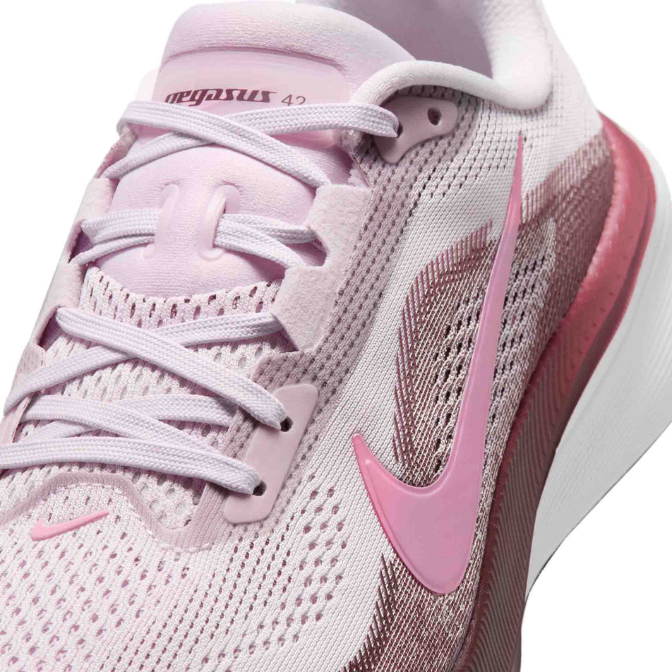Close-up view of the upper of the left shoe from a pair of Nike Women's Pegasus 42 Road Running Shoes in the Bleached Lilac/Pink Rise-Mystic Dates colourway.