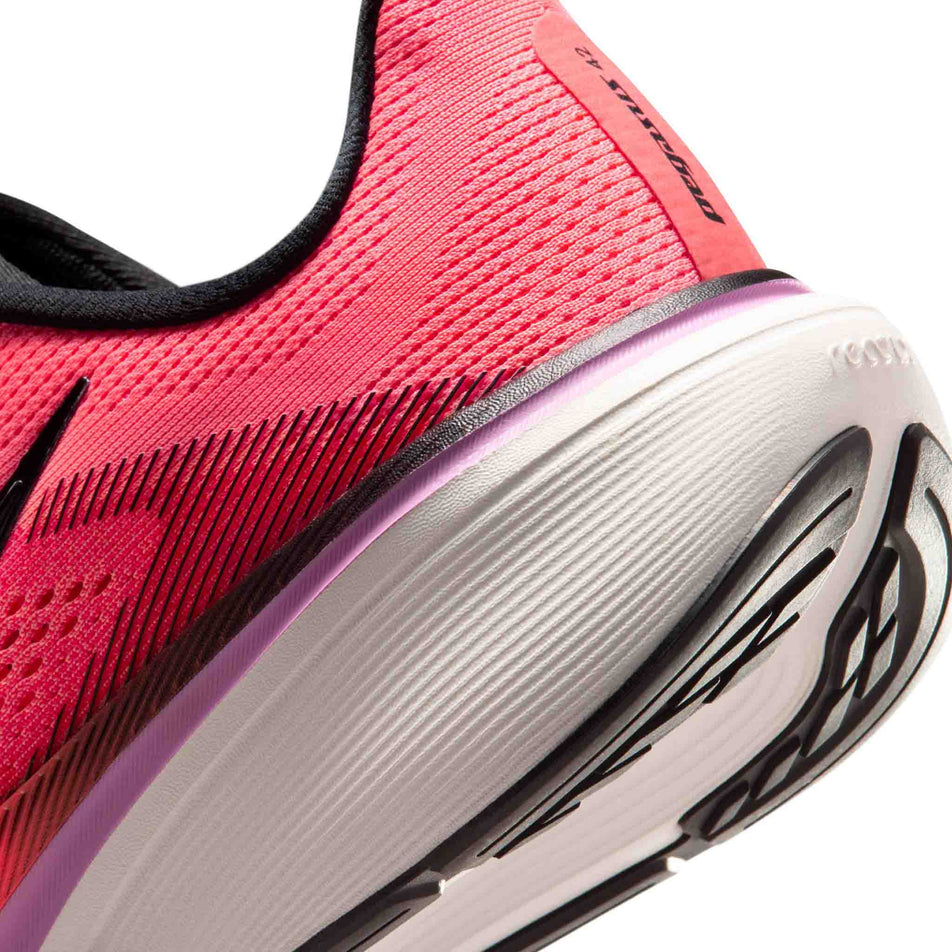 Close-up view of the rearfoot section of the left shoe from a pair of Nike Women's Pegasus 42 Road Running Shoes in the Lava Glow/Black-Flash Crimson-Light Magenta colourway.