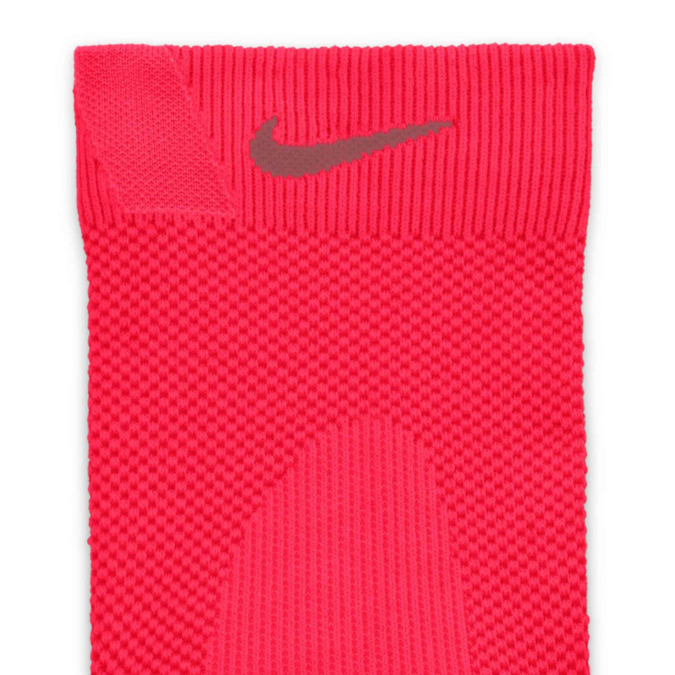 Close-up view of the Nike Swoosh on the front of one of the socks from a pair of Nike Lightweight Running Micro Crew Socks in the Laser Crimson/Light Crimson/Pink Smoke colourway.